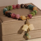 Multicolored beaded bracelet with gold accents on a jewelry box