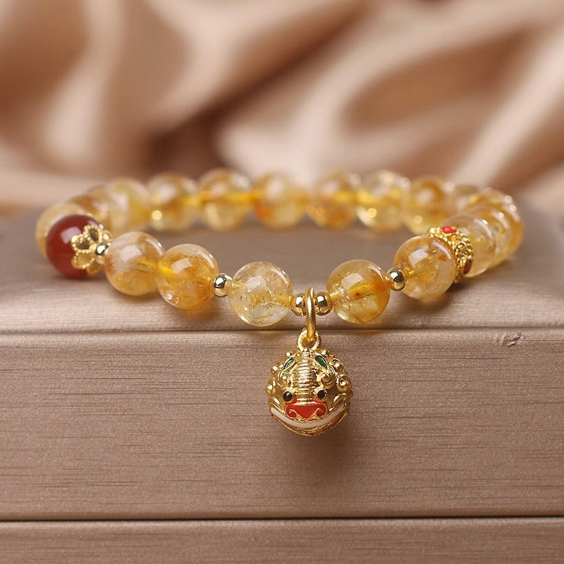 Beaded bracelet with a gold charm on a wooden surface
