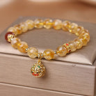 Beaded bracelet with a gold charm on a wooden surface